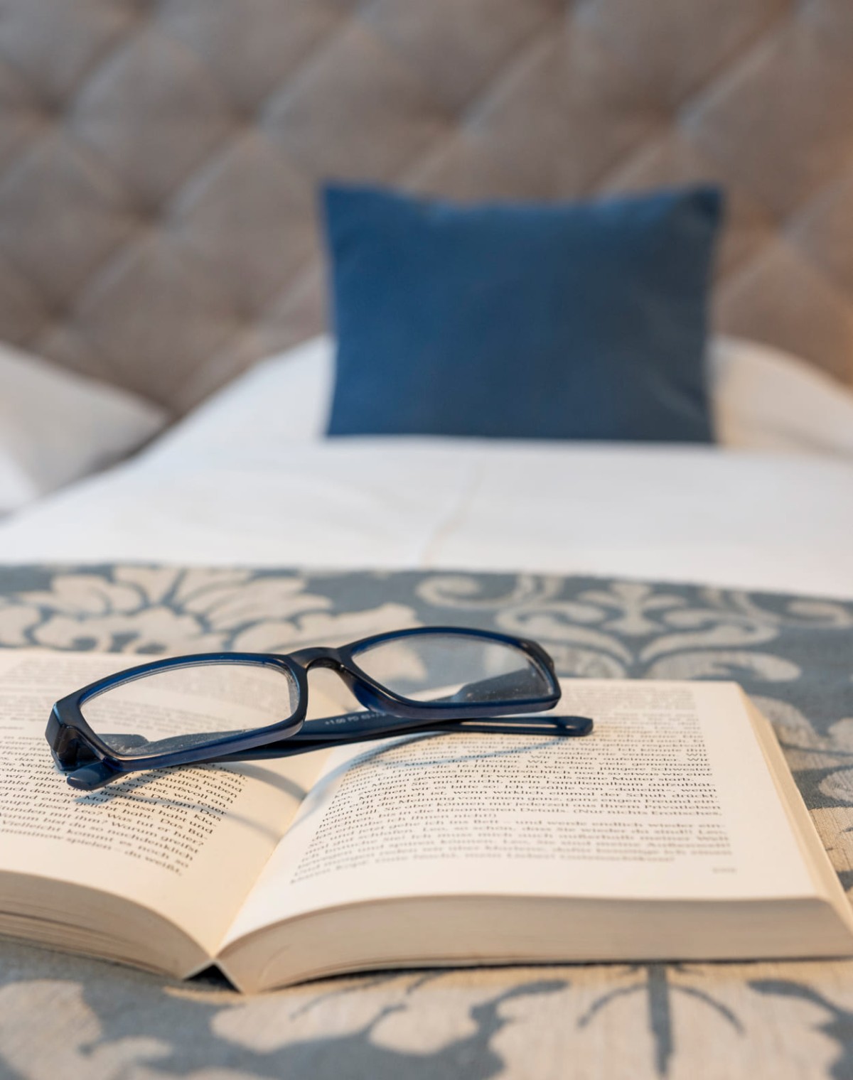 Brille auf dem Bett im Hotelzimmer © Foto von Lorenz Masser